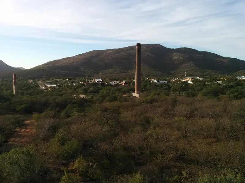 A brick smokestack from El Triunfo's old mine rising above desert scrub and hills
