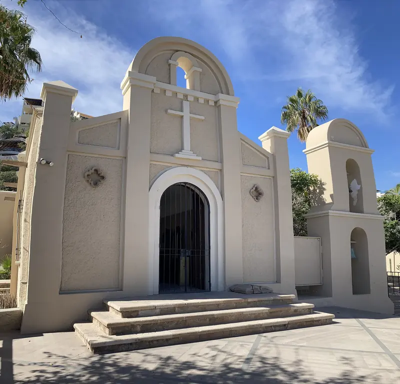 Fachada blanca de la Parroquia de San Lucas, con su cruz y su campanario, en Cabo San Lucas