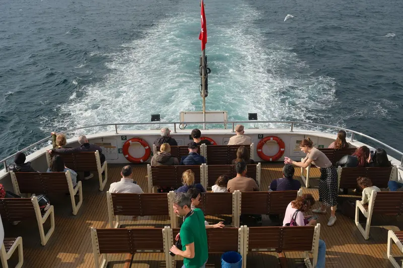 Passengers on the open deck of a shared tour boat on a sunny day at sea