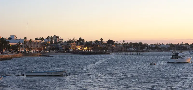 Wide view of the La Paz malecón at dusk with boats on the bay