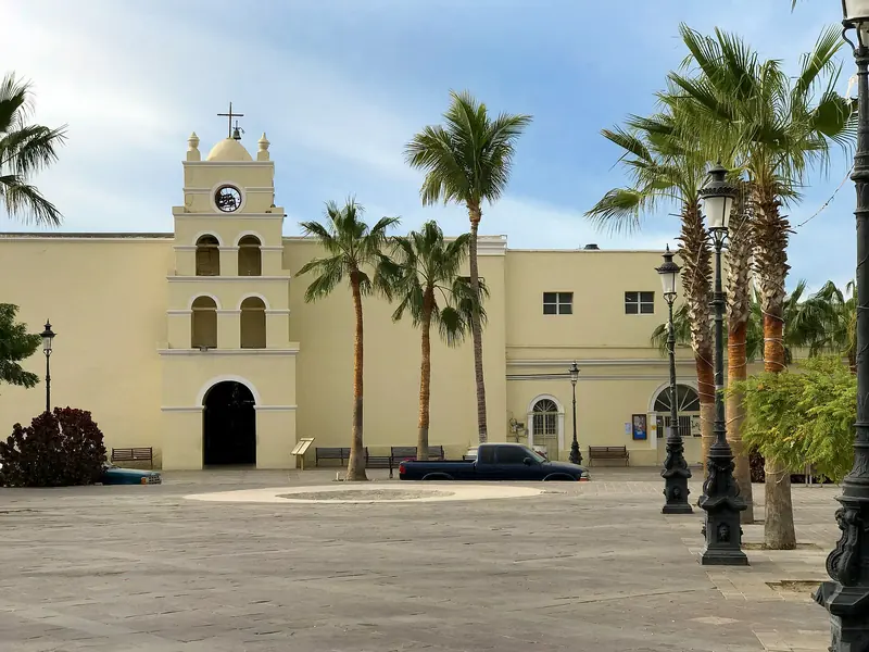 Iglesia de la misión de Todos Santos, Baja California Sur, con su campanario blanco y palmeras