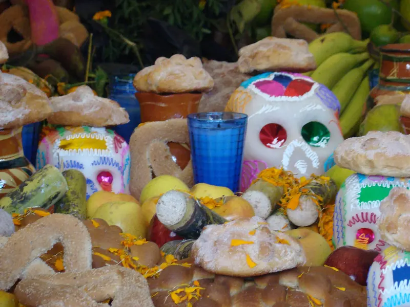Ofrenda de Día de Muertos con pan de muerto, calaveritas de azúcar y fruta en la Ciudad de México