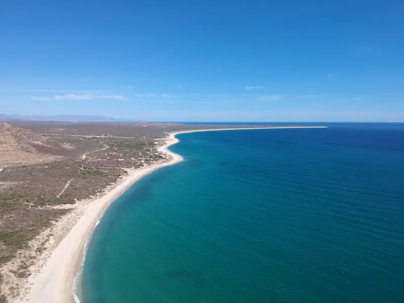 Aerial view of a long sandy beach and clear blue water along the Baja California Sur coast