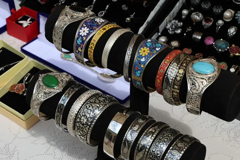 Silver bracelets with colored enamel inlays on display at a jewelry stall