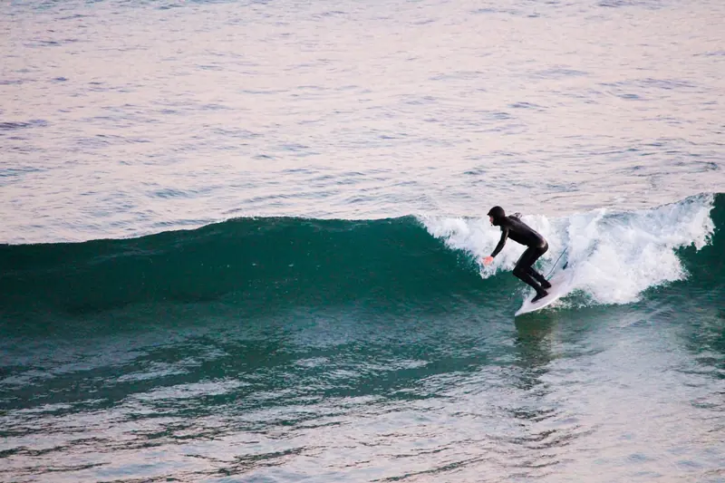Un surfista sobre una ola verde que rompe en espuma blanca
