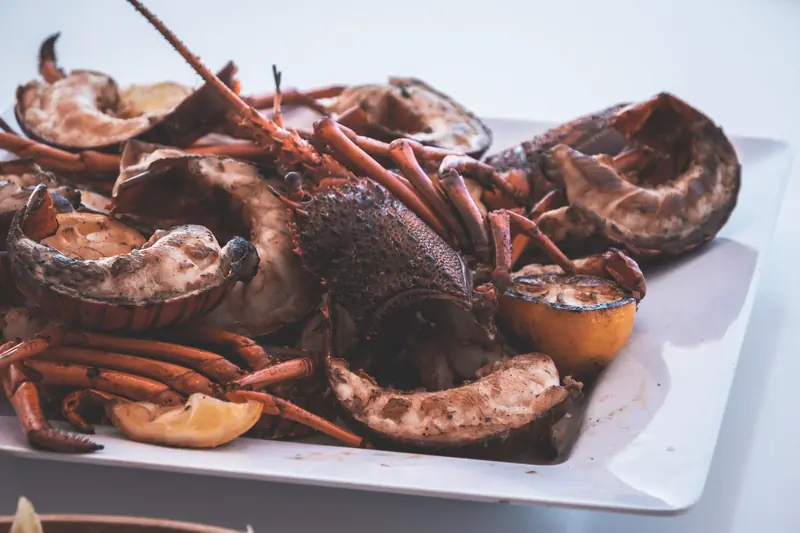 Medias langostas a la parrilla con limón en un plato blanco