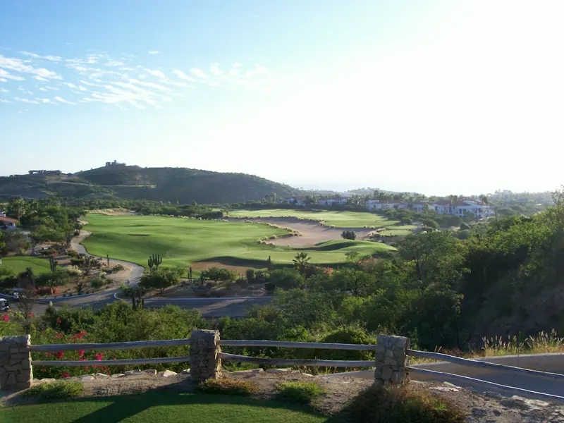 Fairways y greens del campo de golf de Palmilla con casas en las lomas del fondo