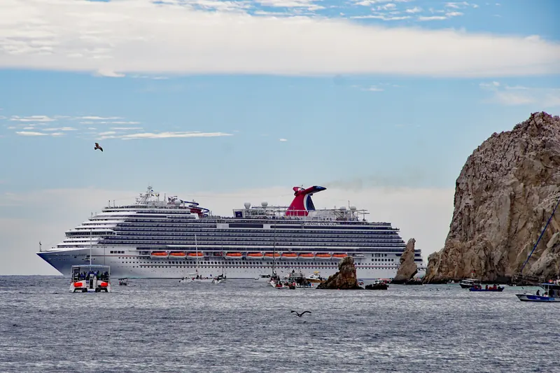 Carnival Panorama anchored off the Arch of Cabo San Lucas, with tenders and water taxis around it