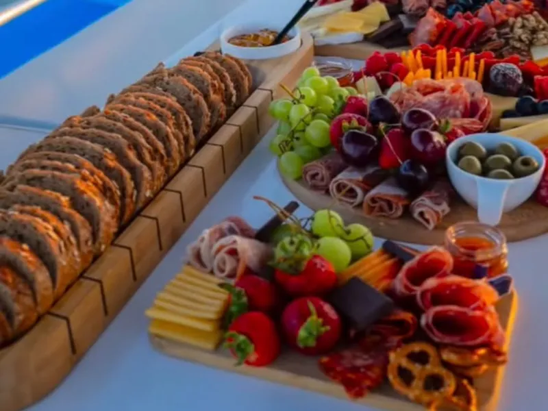 Charcuterie boards, fresh fruit and bread served on the deck of a private yacht