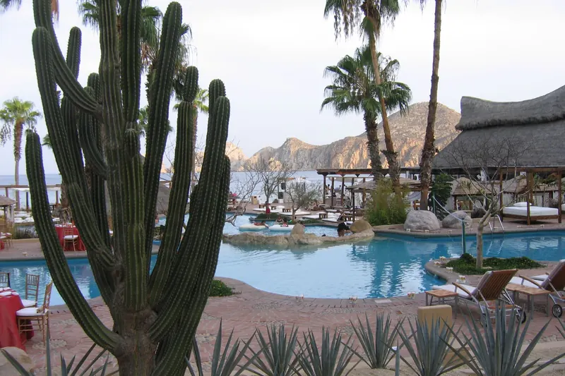 Alberca y palapas de playa del hotel en 2006, cuando era Meliá Cabo San Lucas, con Land's End al fondo