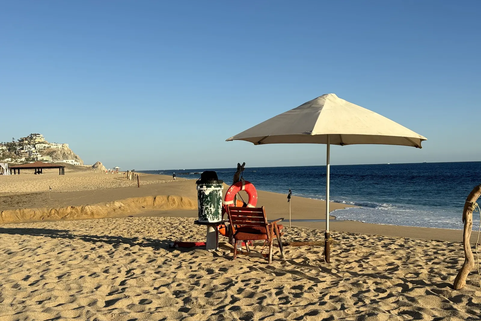 Pacific beach below Pedregal in Cabo San Lucas, with a beach umbrella on the sand