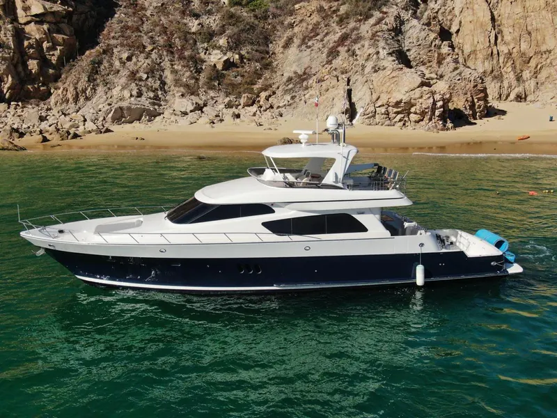 El McKinna 70 anclado frente a una playa de arena entre rocas en Cabo San Lucas