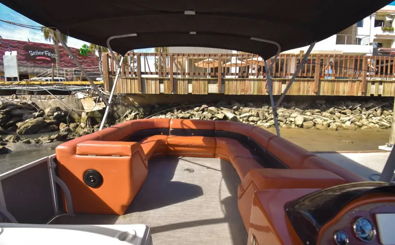 Orange wraparound seating under the shade top on the Pontoon 38