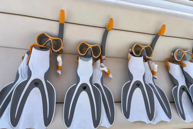 Visores y aletas de snorkel acomodados en un asiento del Sea Ray 55