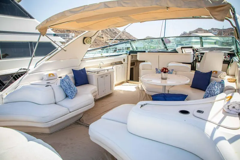 Air-conditioned salon of the Sea Ray 65 with white seating and a table